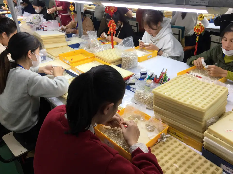 Detailed hand-setting and jewelry component inspection at JINYI JEWELRY manufacturing facility.