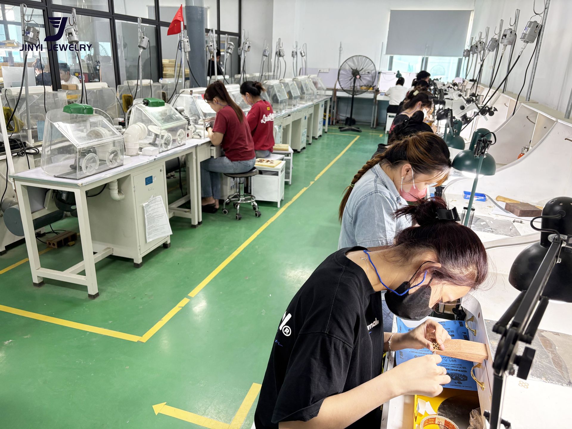 Jinyi Jewelry Factory Vietnam: Artisans at Work in Modern Production Facility | Jewelry Manufacturing Inside the modern Jinyi jewelry factory in Vietnam, skilled artisans engage in detailed jewelry production, hand-polishing custom pieces at specialized workstations.