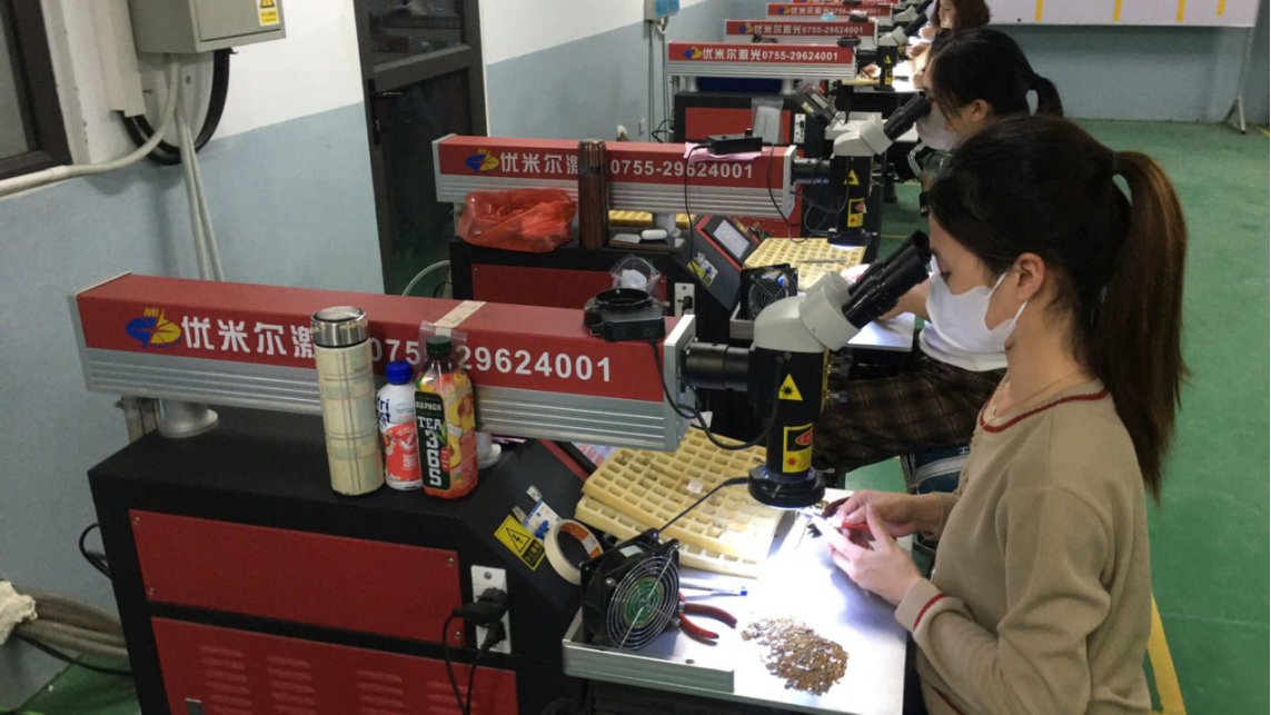 JINYI workshop context for finished-logo review Jewelry workers operating at workshop benches in a company-provided photograph