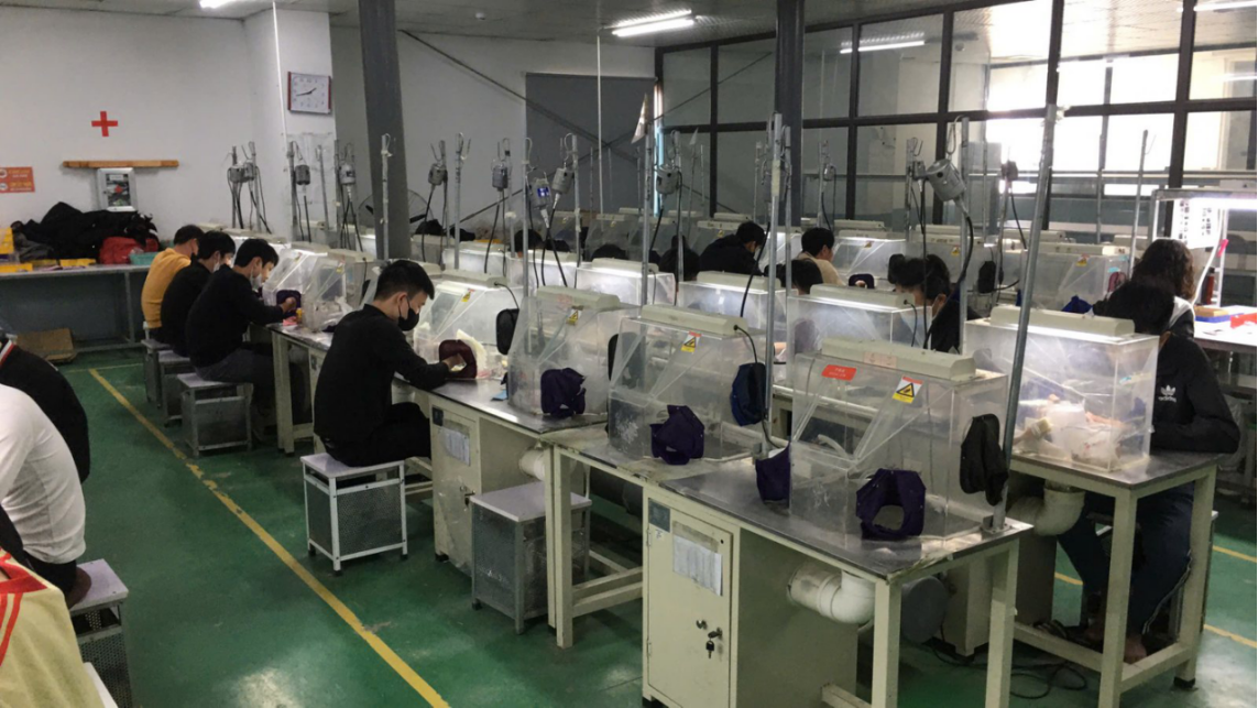 JINYI workshop context for finish-sample review Jewelry workers at workshop benches shown in a company-provided production photograph