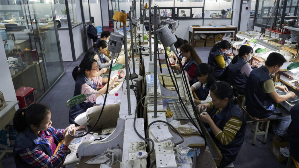 Jewelry workers at bench stations in a JINYI workshop context