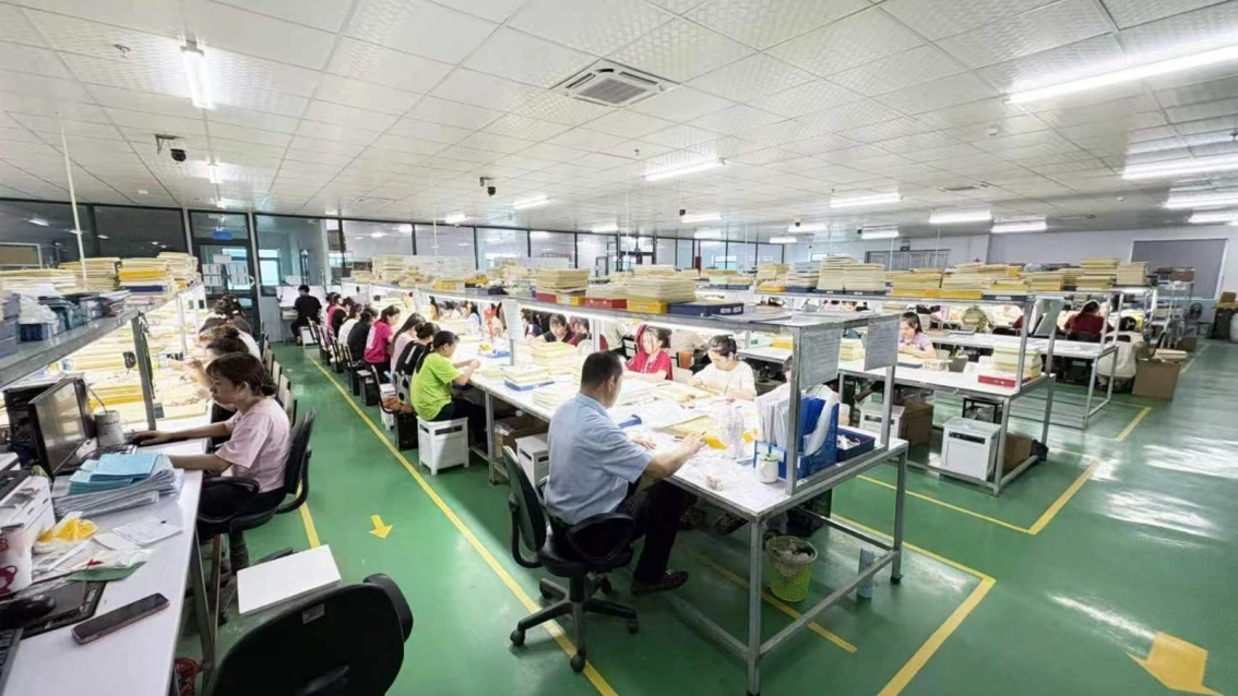 Wide view of an authorized JINYI Vietnam factory workshop with multiple staffed work areas and organized inspection trays